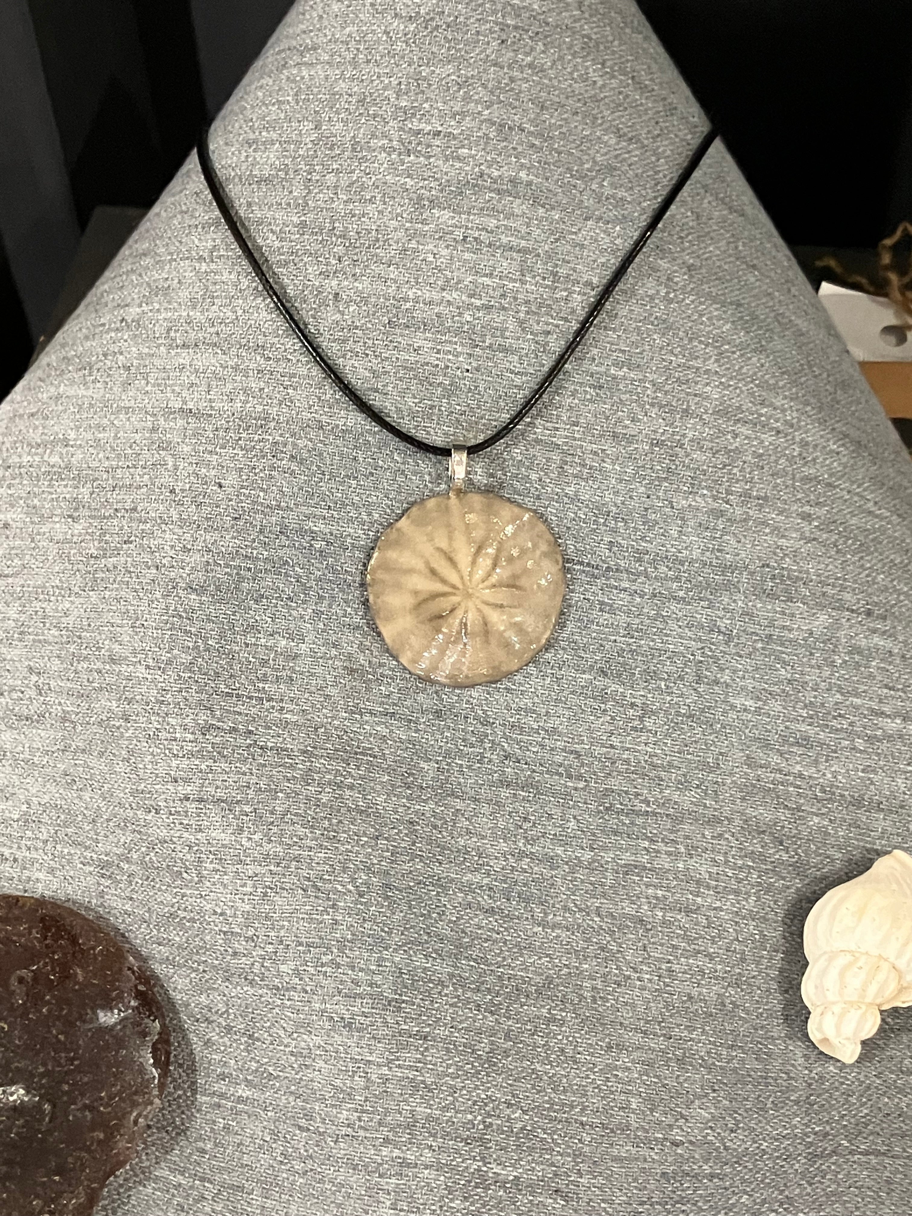 Sand dollar necklace on black cird